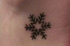 a small snowflake tattoo on the back of a woman's stomach,