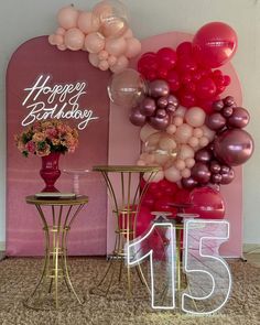 balloons and tables in front of a happy birthday sign