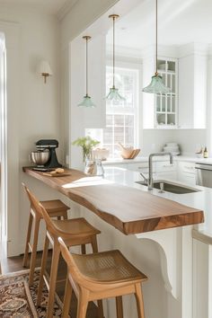 a kitchen with an island and stools in front of the counter top that is made out of wood