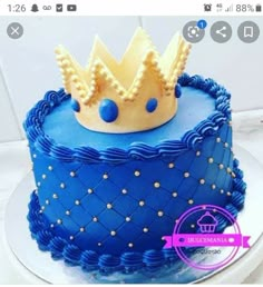 there is a blue cake with a crown on top and gold dots around the edges