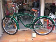 a green bicycle parked in front of a store window