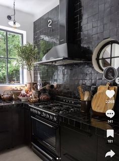 a kitchen with black tiles and wooden cutting boards on the stove top, surrounded by pots and pans