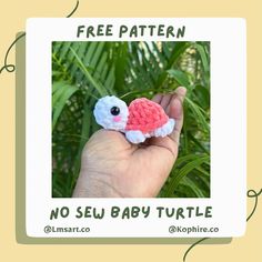 a hand holding a tiny crocheted turtle in it's palm tree habitat