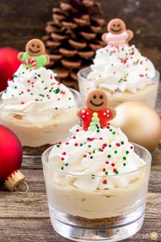 two small desserts with white frosting and sprinkles are on a wooden table