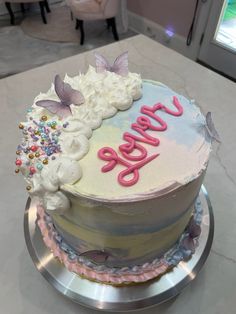 a birthday cake that is decorated with flowers and butterflies