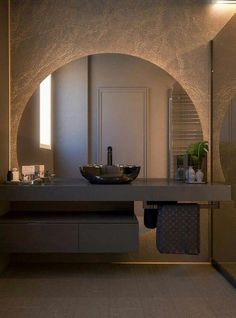 a bathroom with a sink, mirror and counter top in the middle is lit by lights