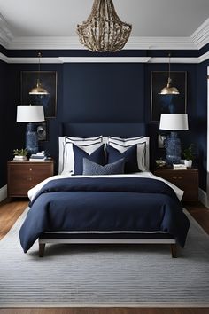 a bedroom with dark blue walls, white bedding and two lamps hanging from the ceiling