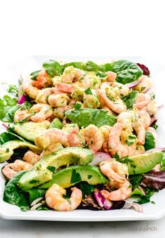 shrimp salad with avocado, lettuce and cilantro on a white plate