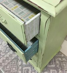 a green cabinet with drawers on top of it