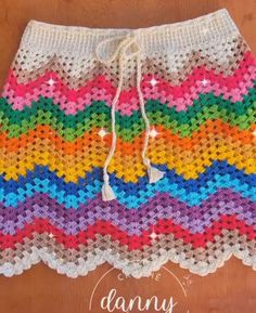 a colorful crocheted skirt with white drawstring on the front and bottom