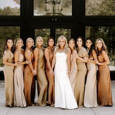 a group of women standing next to each other in front of a large glass window