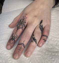 a woman's hand with a spider web tattoo on it