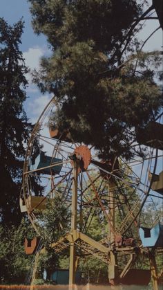 an old ferris wheel with trees in the background