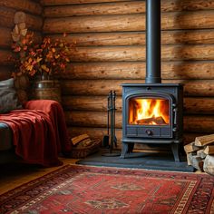 a wood stove in a log cabin with logs and blankets on the floor next to it