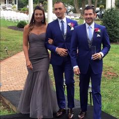 three people in formal wear posing for a photo