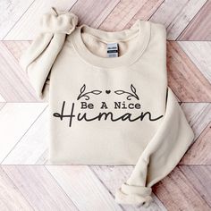 "Are you looking for a sweatshirt that will remind you to be kind? Look no further than our \"Be a Nice Human\" Sweatshirt! The soft, comfortable fabric and inspirational wording will make you feel good every time you wear it. It's also the perfect gift for anyone who loves being kind and wants to show off their personality.  Be Kind Sweatshirt, Nice Human Shirt, Inspirational Shirt, Be a Nice Human Shirt, For Her Gift, Be A Nice Human Sweatshirt, Be A Kind Human Tee, Positivity Hoodie, Be Nice Sweatshirt, Inspirational Hoodie, Nice Human Hoodie, Be Kind T Shirt, Motivational Shirt #bekind #beakindhuman #positivity #bekindshirt A sturdy and warm sweatshirt bound to keep you warm in the colder months. A pre-shrunk, classic fit sweater that's made with air-jet spun yarn for a soft feel and r Positive Hoodie, Be Kind Shirt, Being Kind, Positive Shirt, To Be Kind, Kindness Shirts, Fun Sweatshirts, Inspirational Shirt, Be A Nice Human