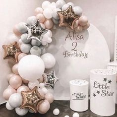 a birthday decoration with balloons and stars on the front, along with other decorations for a baby's first birthday