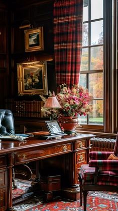 a room with a desk, chair and flowers in the vase on the window sill