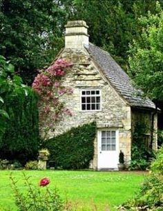 an old stone house surrounded by greenery and trees