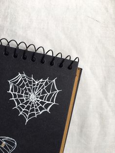 a spiral notebook with spider web on it