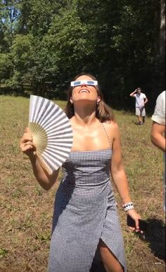 a woman in a dress is holding a fan