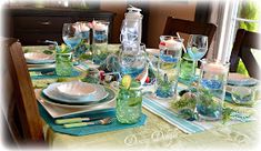 the table is set with dishes and place settings for an ocean themed dinner or brunch