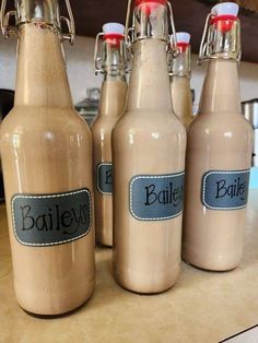 four bottles with labels on them sitting on a counter