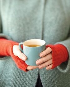 a woman holding a cup of tea in her hands