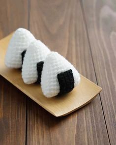 two small white and black sheeps on a wooden plate with wood planks in the background