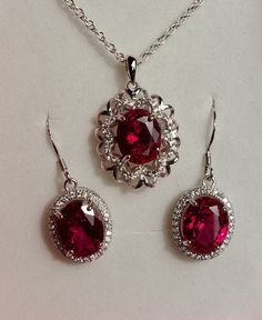 "Beautiful Deep Red Gem Necklace And Earring Set, 8x10mm Lab Grown Ruby Gems, 925 Sterling Silver Rhodium Plated Pendant With Cubic Zirconia Trim, 18\" Sterling Chain. 925 Sterling Rhodium Plated Earrings, Ear Wire Style. Gift Box Included." Luxury Red Danglers As Gift, Ruby Wedding Jewelry, Luxury Lab-created Ruby Necklace Gift, Ruby Jewelry Aesthetic, Red Sterling Silver Fine Jewelry, Classic Red Cubic Zirconia Jewelry, Anniversary Sterling Silver Jewelry Sets With Sparkling Stones, Classic Red Jewelry With Lab-created Ruby, Classic Red Lab-created Ruby Jewelry