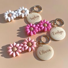 four personalized keychains with flowers on them sitting next to eachother