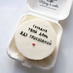 a white cake in a plastic container with writing on the side and a red heart