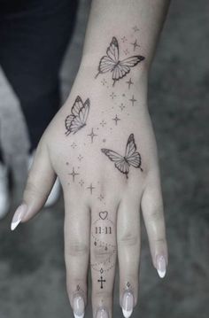 a woman's hand with tattoos and butterflies on it