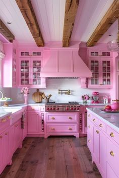 a kitchen with pink cabinets and wooden floors