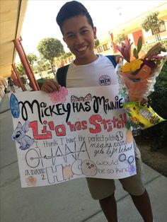 a young man holding up a sign that says mickey has minnie