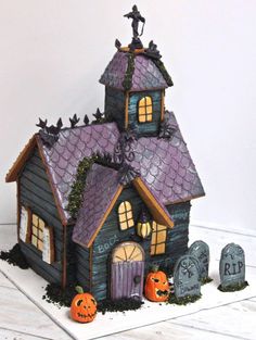 a halloween house with pumpkins and tombstones around it