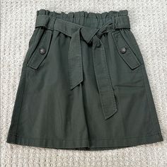 Nwt Loft | 100% Cotton Olive Green Belted Mini Skirt | Size 0 + Side Pockets With Decorative Button Detail + Sash Tie Belt + Paperbag Style Stretchy Waist + 100% Cotton Material, Feels Really Nice + Cool Olive Green Color + Mini Length + Perfect Condition Approximate Flat Measurements + Waist 13" + Length 19" Offers Welcome Belted Mini Skirt, Olive Green Color, Tie Belt, Button Detail, Green Color, Cotton Material, Olive Green, Really Cool Stuff, Mini Skirt