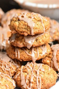 a pile of cookies with icing on top of them sitting on a cooling rack