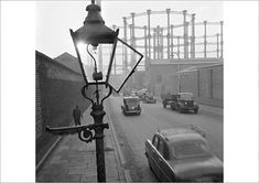 an old photo of cars driving down the street