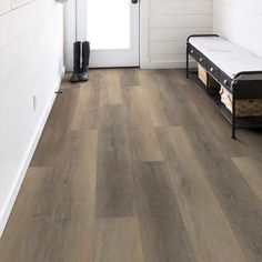 a hallway with white walls and wood flooring