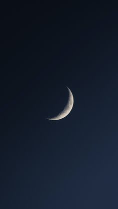 the crescent moon is seen against a dark blue sky