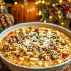 a white bowl filled with pasta and meat on top of a table next to pine cones