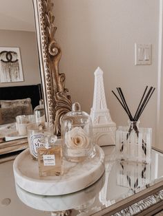 a vanity with perfume bottles and candles on it