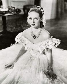 an old black and white photo of a woman in a dress