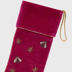 a pink velvet bag with gold stars and bells on the side, hanging from a chain