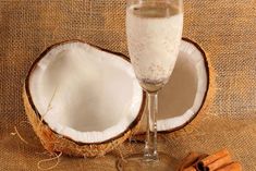 a glass of milk next to an open coconut