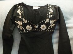 Tight fitting  black stretch long sleeve top. Designer Hunza. 90% cotton, 10% With beautiful crystal, pearl and sequin embellishment. Although the label says S/M it does fit tight so more like a Small. Fitted Long Sleeve Tops With Sequins, Fitted Rhinestone Tops For Fall, Elegant Long Sleeve Tops With Rhinestones, Glamorous Long Sleeve Tops With Rhinestones, Whimsigoth Tops, Tight Clothes Outfits, Whimsigoth Outfits, 80s Clothing, 80s Look