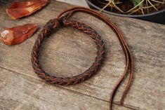 "Made by hand, this leather bracelet is made with a round braid of 6 strips of 0.2 cm / 0.08 in. Measuring 0.7 cm / 0.28 in in diameter and made with premium leather, it is finished with a knot clasp that easily adjusts to the shape of the wrist with two long straps. A lightweight and comfortable to wear bracelet, finished and handcrafted. Ideal for a long-lasting gift. WRIST MEASUREMENT: To find out the size of your wrist, take a seamstress meter or a string and a ruler. Wrap your wrist between Handmade Waxed Cord Braided Bracelet, Handmade Rustic Braided Bracelets As Gift, Rustic Handmade Braided Bracelets For Gifts, Rustic Handmade Braided Bracelets As Gift, Rustic Handmade Braided Bracelet Gift, Round Braid, Handmade Leather Jewelry, Knot Braid, Leather Artisan