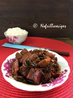 a white plate topped with meat and rice