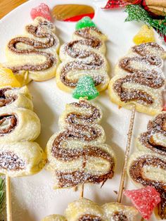 a white plate topped with pastries covered in powdered sugar next to christmas decorations